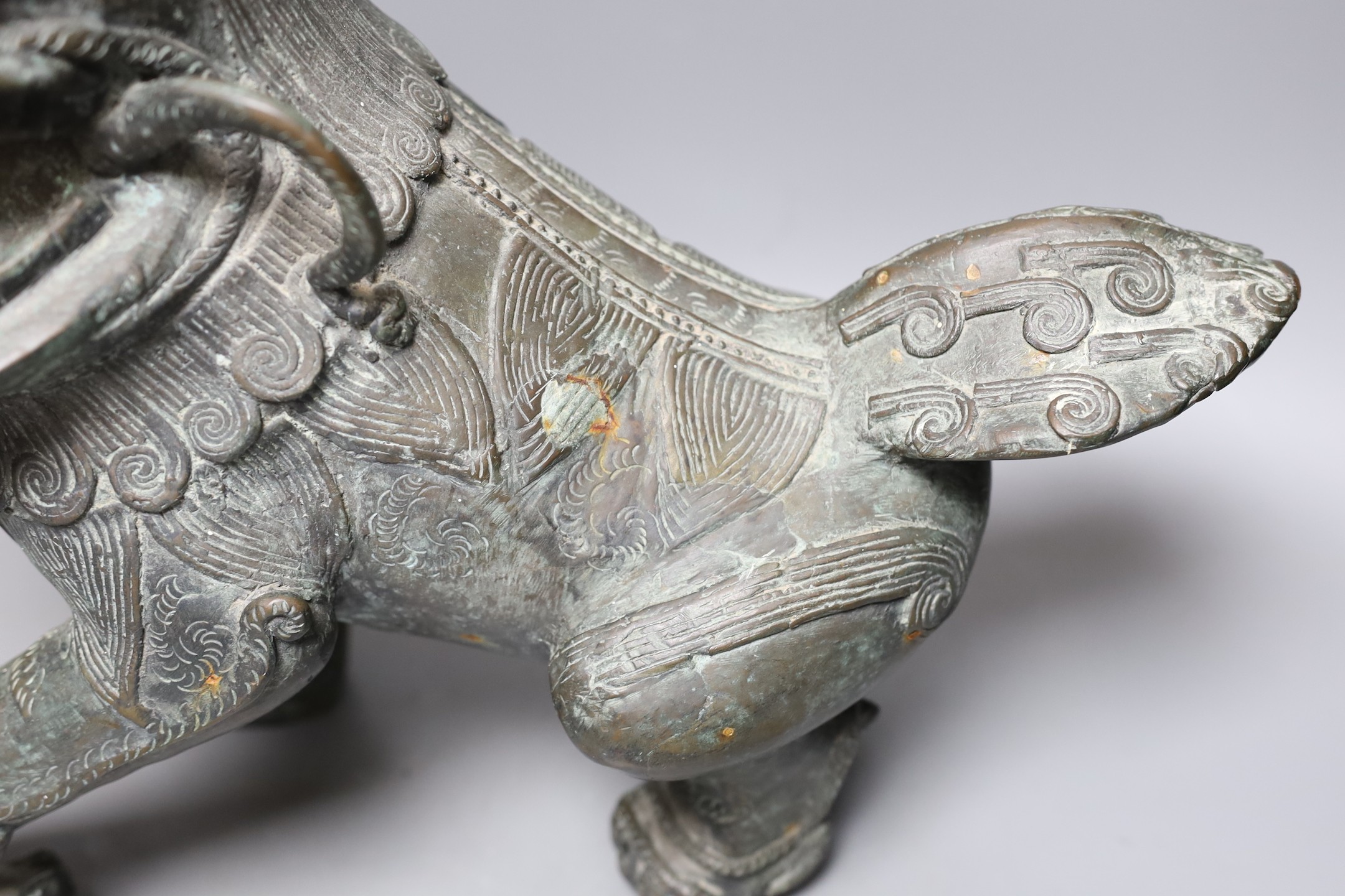 A large spSouth East Asian cast bronze metal floor-standing temple lion with iron spurs, 40cm tall